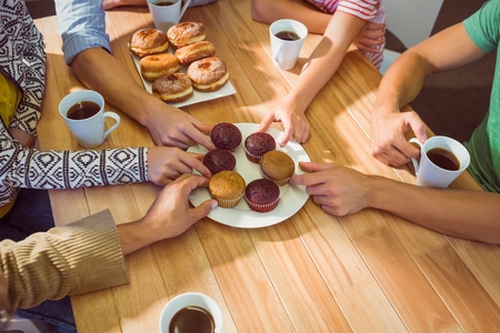 Geschäftsleute, die Kuchen auf Tabelle nach dem Mittagessen im Büro nehmen