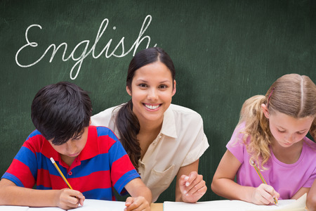 The word english and pretty teacher helping pupils in library against green chalkboard