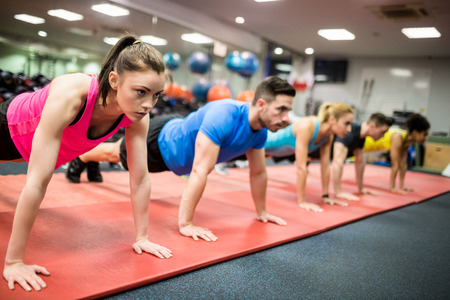 Fit people working out in fitness class at the gym Фото со стока