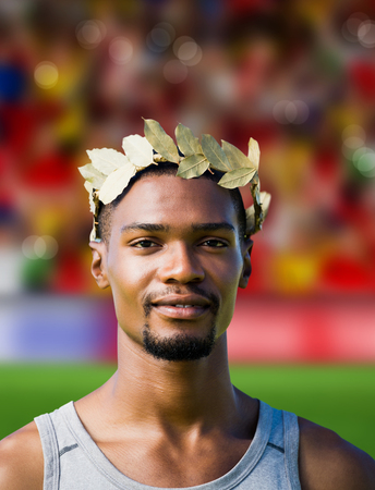 群衆の中にぼやけてサッカー ピッチに対して月桂樹の冠を持つ勝利のスポーツマンの肖像 の写真素材 画像素材 Image