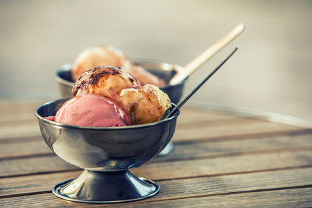 ice cream: Kem trong hai bát kim loại retro trên một chiếc bàn gỗ. Backgrounds tạo cho văn bản của bạn.