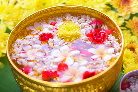 Colorful flower in water bowls decorating on Banana leaf for Songkran Festival or Thai New Year. Фото со стока