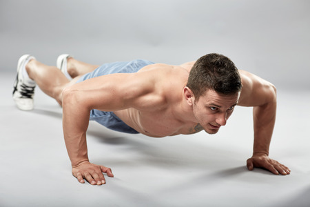 man doing pushup dips between two chairs in studio stock photo