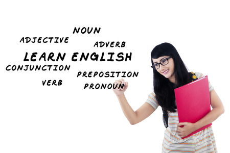 Female student writes english language materials on whiteboard