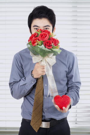 若い中国人男性の花とギフトの花束を持って心の背景で撮影 彼のガール フレンドで驚きを与えるための写真 の写真素材 画像素材 Image 若い中国人男性の花とギフトの花束を持って心の背景で撮影 彼のガール フレンドで驚きを与えるための写真 の写真素材 画像素材 Image