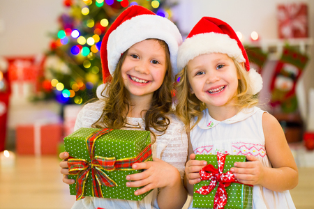 Two Little Girls With Presents Around The Christmas Tree Stock Photo Two Little Girls With Presents Around The Christmas Tree Stock Photo