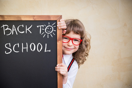 School kid in class. Happy child holding blackboard blank. Education concept Stock Photo - 41382177