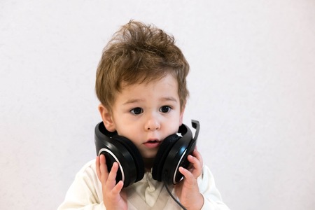 Pop Music Happy Smiling Newborn Baby Listens To Music In Headphones On Gray Background Pop Music Happy Smiling Newborn Baby Listens To Music In Headphones On Gray Background