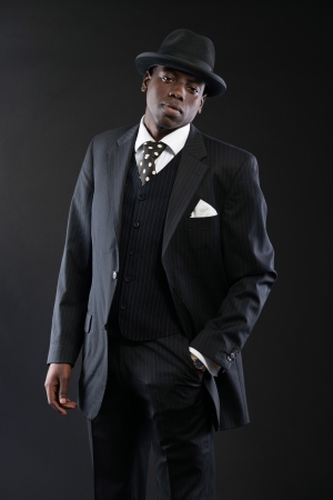 レトロなアフリカ系アメリカ人のギャング ストライプ スーツにネクタイと黒の帽子を着ています スタジオ ショットします の写真素材 画像素材 Image