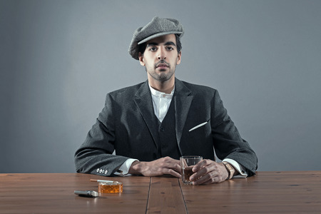 マフィア ファッションの男が白いストライプのスーツとグレーのキャップを身に着けています スタジオ撮影します の写真素材 画像素材 Image