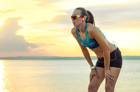 Mujer Corriente En Gafas De Sol Deportivas Corredor Femenino Con Su Teléfono Inteligente Entrenamiento De Entrenamiento Al Aire Libre En La Playa Hermosa Modelo De Fitness De Raza Mixta En Forma Al