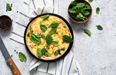 Quiche au saumon et épinards, fromage sur fond béton clair. vue d'en-haut.