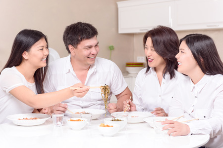 Wie zu Hause. Asiatische Familie schließlich nach Hause zusammen alle und Essen Stockfoto