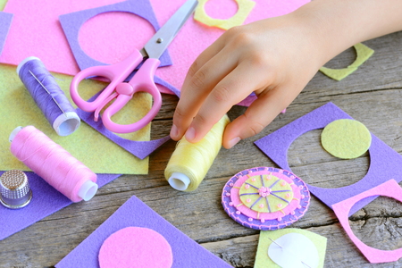 子どもの概念を手で縫います 小さな子供は フェルト円から花を作った 子スレッドを手に取る 花を感じビーズ工芸 クラフト用品木製のテーブル 簡単かつ迅速なアップリケ の写真素材 画像素材 Image 7465